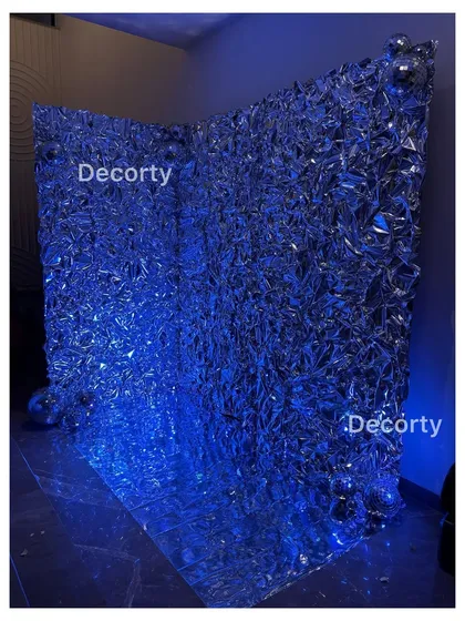 The same foil backdrop illuminated with blue light, showing how it can be transformed to match any color scheme or party mood.