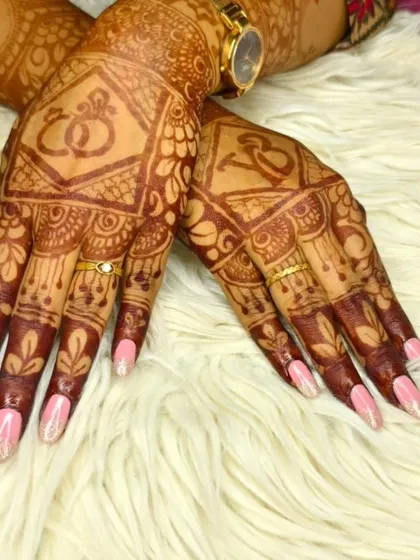 Elegant pink gel polish with a glitter fade, perfectly complementing intricate bridal henna. A beautiful choice for wedding festivities.