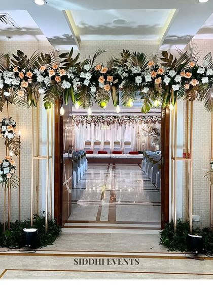 A detailed view of the grand entrance, showing the intricate floral arrangements and modern gold-toned structures that frame the doorway.