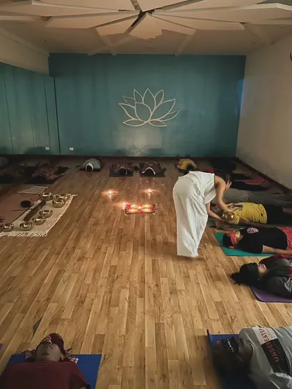 I gently use a singing bowl near a participant's body, a technique known as vibrational therapy. This focused application helps to deepen the healing effect on a specific energy center, or chakra.
