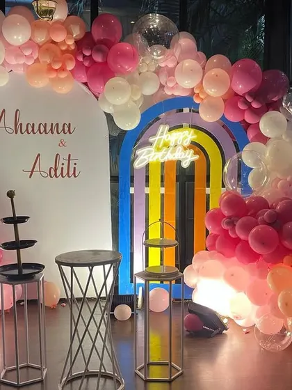 A close-up of the pastel-themed first birthday, showing the details of the balloon colors and the custom name sign.