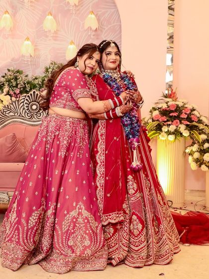 A beautiful photo of the two sisters. Both are wearing gorgeous lehengas and makeup that complements their outfits.