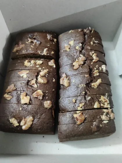 My Chocolate Walnut loaf cake is a rich and fudgy treat packed with crunchy walnuts. Here are two loaves, sliced and boxed up for a customer.