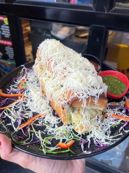 My Italian Sandwich is a hearty and cheesy meal. It's loaded with vegetables and cheese, served on a bed of salad with chutneys.