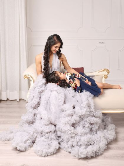 A quiet, tender moment between a mother and her daughter. The voluminous gown and elegant setting create a fairytale-like atmosphere.