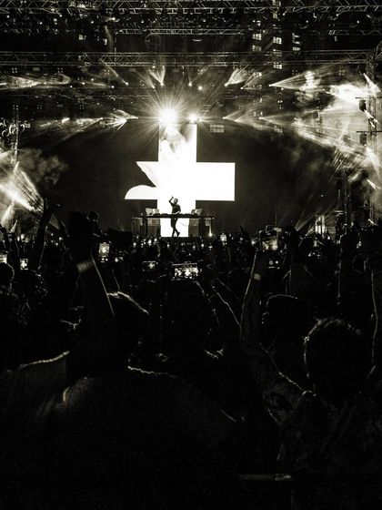 Another artistic black and white photo, focusing on the scale of the crowd and the stage.