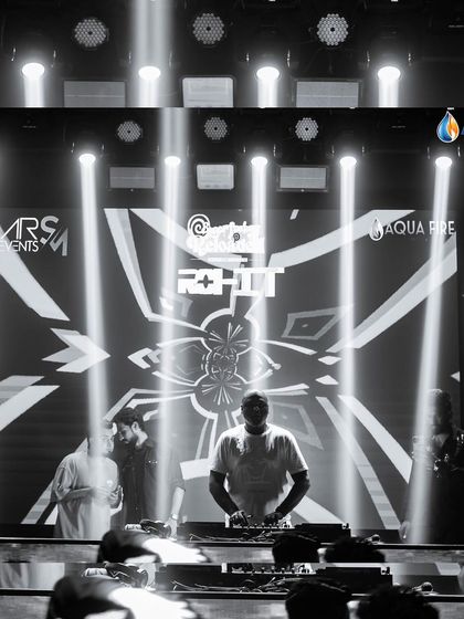 A dramatic black and white shot of me at the decks, with spotlights creating a powerful visual.