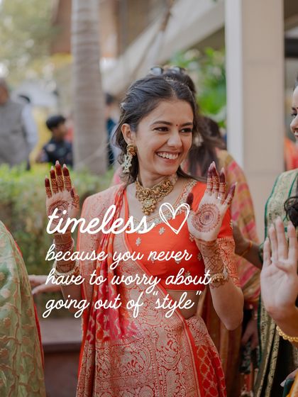 An image capturing the essence of our 'Wedding Wardrobes We Love' book. This bride's timeless orange lehenga for her mehendi is a perfect example of a classic look that never goes out of style.