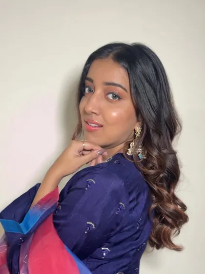A side profile showing off the glowing skin and the sharp wing. Her hair is styled in soft curls to complete this elegant look.