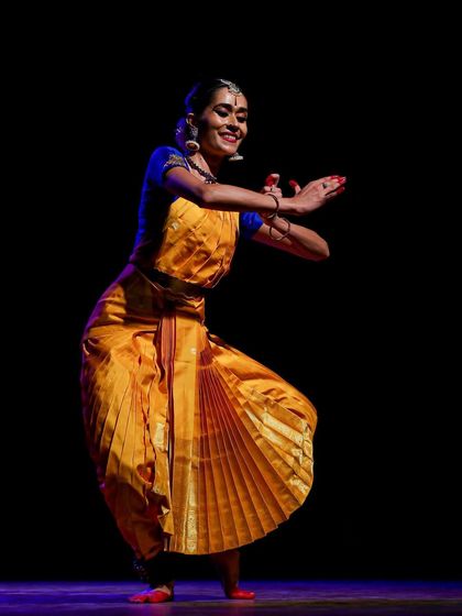 A lively moment on stage, where the expression and posture convey a sense of playful storytelling, engaging directly with the audience.