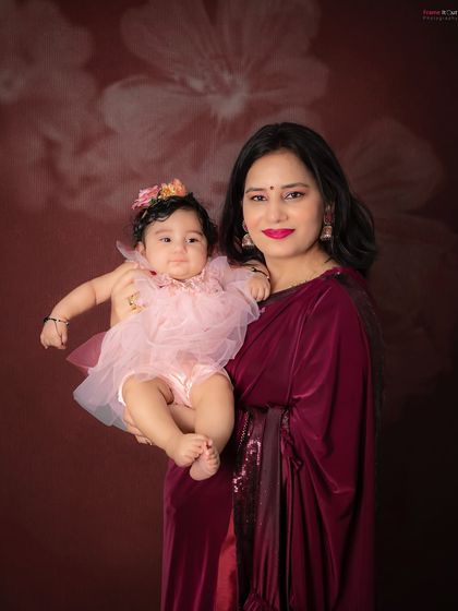 A beautiful mother and daughter portrait. The rich colors and soft floral backdrop create a warm and elegant feel.