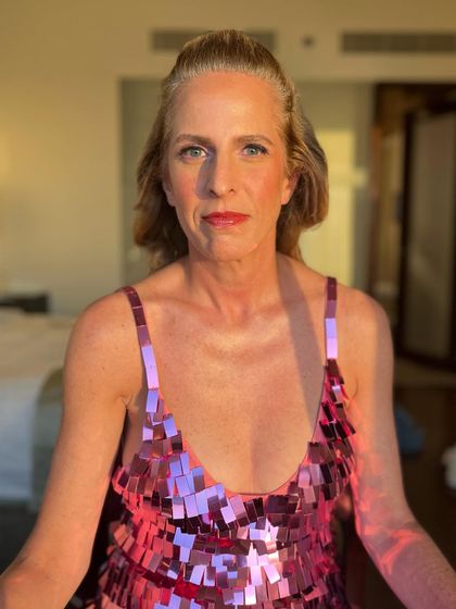 A close-up of the party look. The shimmery pink dress is paired with a matching pink lip and soft, glowing skin for a fun and festive feel.