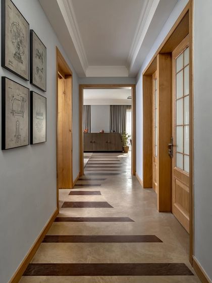 This corridor in the Aalay home uses patterned flooring to create a sense of direction and visual interest, connecting the private rooms to the shared living spaces. The design demonstrates how circulation paths can become thoughtful architectural features.