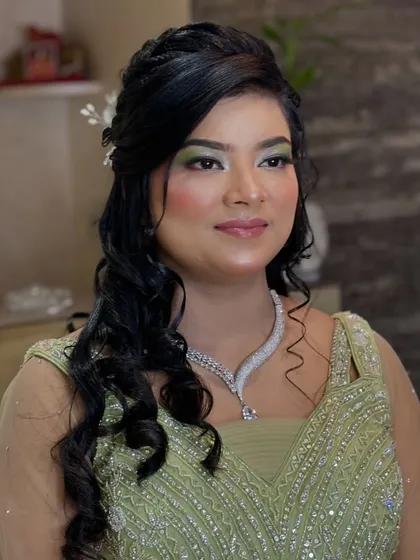 A party look with a pop of color. The shimmery green eyeshadow adds a fun and unexpected element to her elegant green gown.
