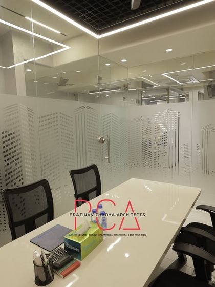 This meeting room uses frosted glass partitions with a cityscape graphic to provide privacy without completely closing off the space. The design maintains a connection to the urban environment while ensuring a focused work area.