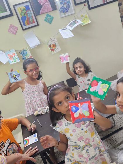 The proud moment when they finish their artwork! Our students showing off the butterfly paintings they created during our Children's Day celebration.