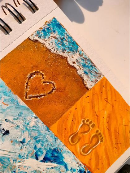 Another close-up of the beach painting, focusing on the heart drawn in the sand and footprints.