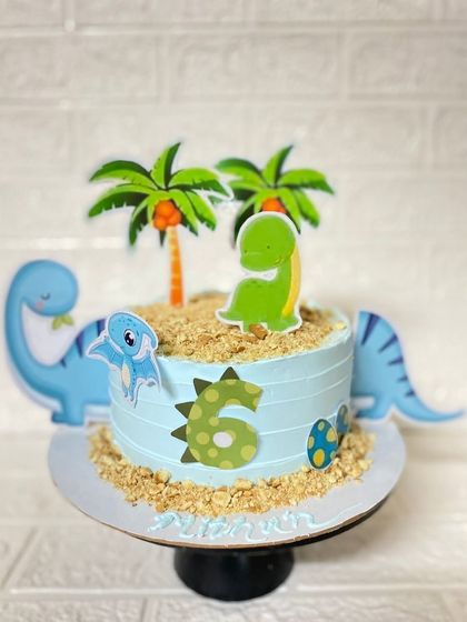 A rawrsome dinosaur cake for a 6th birthday. This butterscotch cake is decorated with edible sand and cute dino toppers.