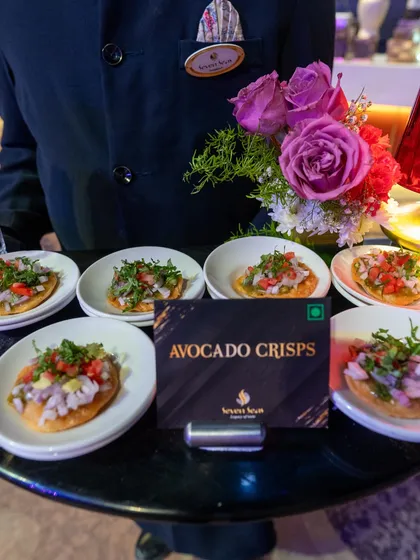 A server presents a tray of our signature Avocado Crisps, a perfect bite-sized appetizer for any sophisticated event.