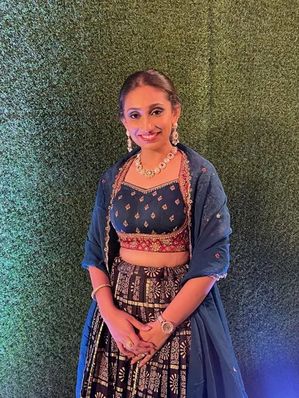 The happy client with her pearl ponytail, a perfect choice for a sangeet or reception.