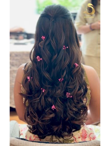 A back view of the soft curls with scattered pink baby's breath.
