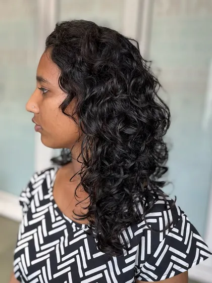 A side view of the student's curly haircut, showing the beautiful layers and how they frame the face.