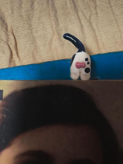 A quirky bookmark featuring a cat's behind, peeking out from the top of a book. It's a playful and humorous piece from my 'Paw-try' collection.