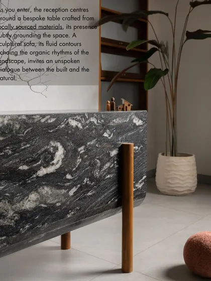 The reception area of our studio centers around a bespoke table crafted from locally sourced materials. Its presence subtly grounds the space, while the fluid contours of the sofa echo the organic rhythms of the landscape.