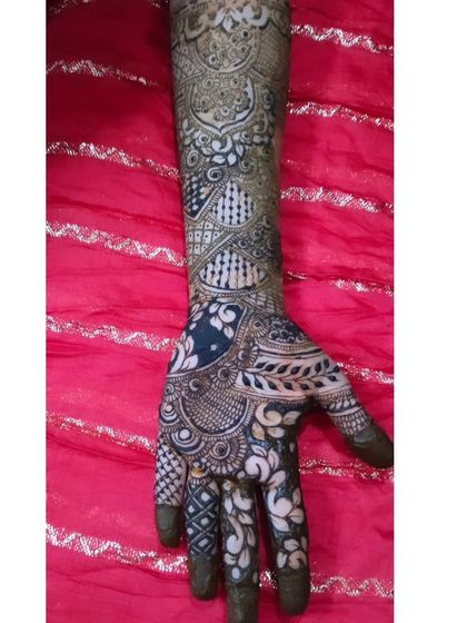 A full-arm bridal design featuring negative space, where the skin is part of the pattern. This advanced technique creates a bold, dramatic look that is truly unforgettable.