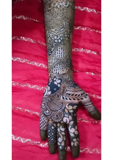 This design uses negative space to create a bold, modern look while still providing full coverage up the arm. The contrast between the dark paste and the skin is striking.