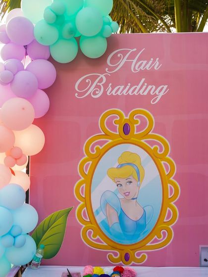 A dedicated hair braiding station, themed with a Cinderella backdrop, where guests can get princess-worthy hairstyles.