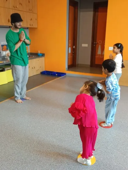 An instructor and students starting the class with a traditional 'namaste'. This moment of calm focus is an important part of our class structure.