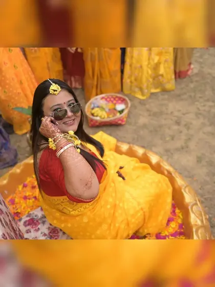 Capturing the fun side of a Haldi ceremony with a high-angle shot of the bride looking up with a smile. These playful, unposed moments are an essential part of your wedding story.