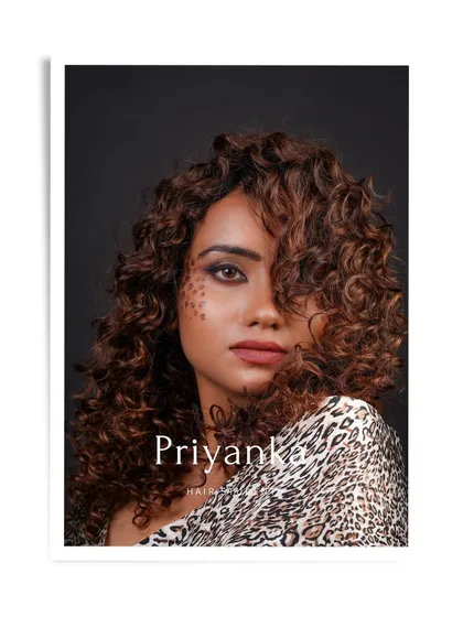 A professional portfolio shot of hair student Priyanka's work, featuring a beautiful curly style and creative makeup.