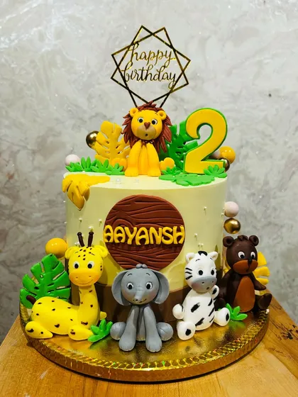 A jungle animal cake for Aayansh's 2nd birthday, with friendly fondant creatures like a lion, elephant, and giraffe.