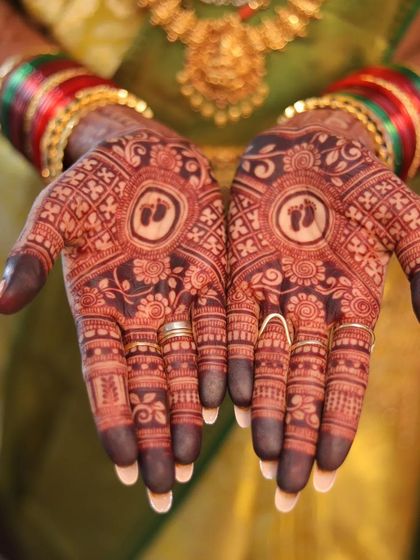 A professionally captured photo of the final baby shower mehendi stain. The deep color highlights the intricate details surrounding the central baby feet motif.