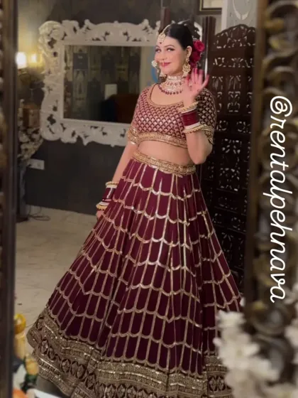 A happy client posing in the mirror with the maroon scalloped lehenga.