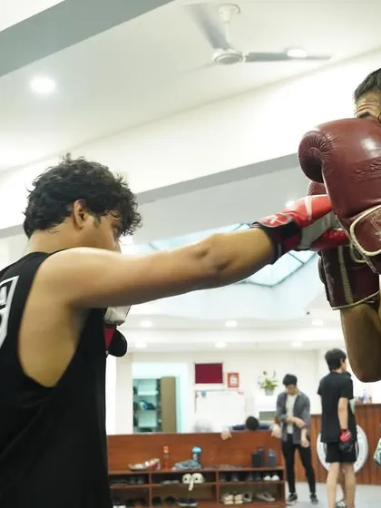 A student practices their jab-cross combination during a partner drill. Repetition is the mother of skill, and we drill the basics until they become second nature.