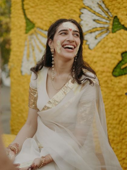 The bride's infectious laugh during her Haldi, her face smeared with turmeric, a picture of pure joy.