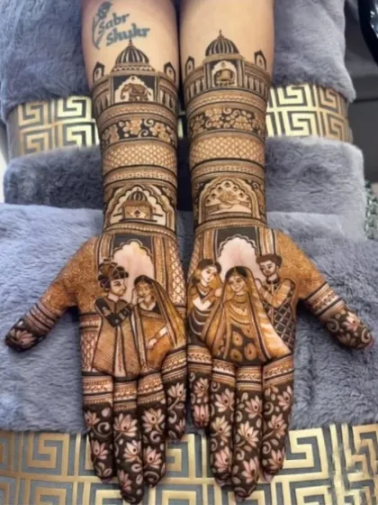 A lovely family portrait mehandi, showing the couple with their parents, framed by beautiful palace architecture on the arms.