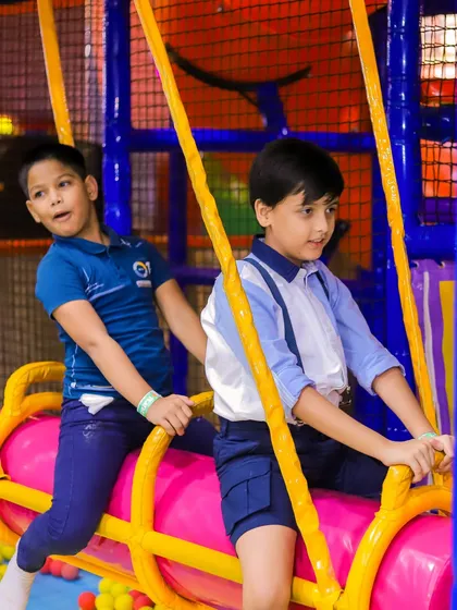 Teamwork on the swinging log. This activity encourages kids to play together and develop balance and coordination in the ball pit area.