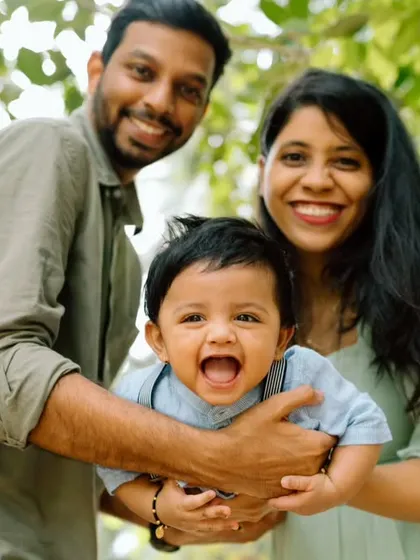 A close-up, joyful portrait of a family enjoying their time together outdoors. The baby's wide-open laugh is infectious and shows the real, happy moments I strive to capture.