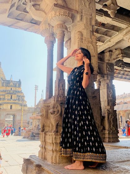 A traveler enjoying the architectural beauty of a Hampi temple.