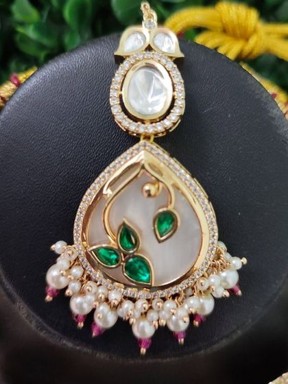 The maang tikka for this set, perfectly echoing the design of the main necklace pieces for a cohesive and polished look.