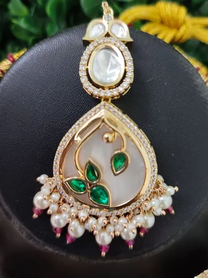 The maang tikka for this set, perfectly echoing the design of the main necklace pieces for a cohesive and polished look.