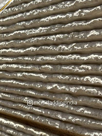 An extreme close-up of the Ittimi clay cladding, highlighting its natural, earthy texture. It's a surface that is as beautiful to touch as it is to see.