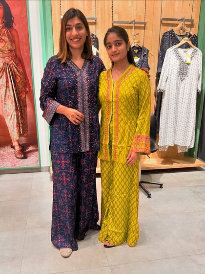 Helping a client choose between two beautiful festive outfits at the Global Desi store.
