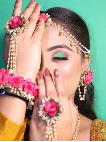 A side profile showcasing the floral earrings and maang tikka. This is a great example of how my floral sets can complete your Haldi or Mehendi look.