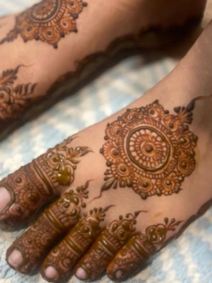 A close-up of a detailed foot design with a central mandala and intricate patterns on the toes.