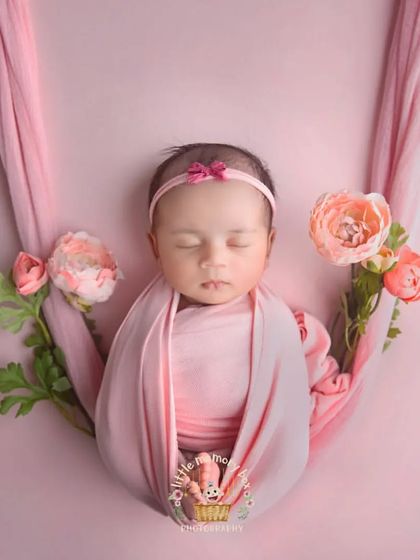 This hanging sling pose is so beautiful and delicate. I use soft fabrics and flowers to create a floating, dream-like effect, always ensuring the baby is completely safe.